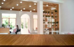 leeg donker houten tafel in voorkant van abstract wazig bokeh achtergrond van restaurant . kan worden gebruikt voor Scherm of montage uw producten.mock omhoog voor ruimte. foto
