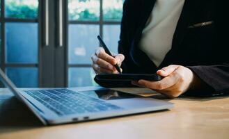 dichtbij omhoog handen multitasking Mens gebruik makend van tablet, laptop en mobiele telefoon Verbinden Wifi foto