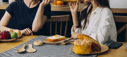 lachend groep van verschillend jong vrouw hangende uit Bij huis samen en aan het eten pizza foto