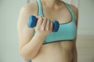 dichtbij omhoog beeld van aantrekkelijk fit vrouw in Sportschool foto