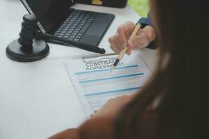 zaken en advocaten bespreken contractpapieren met koperen schaal op bureau in kantoor. wet, juridische diensten, advies, rechtvaardigheid en wet concept foto met film grain effect