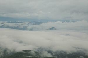 berg reeks met zichtbaar silhouetten door de ochtend- blauw mist. foto
