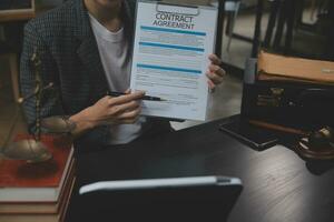 zaken en advocaten bespreken contractpapieren met koperen schaal op bureau in kantoor. wet, juridische diensten, advies, rechtvaardigheid en wet concept foto met film grain effect