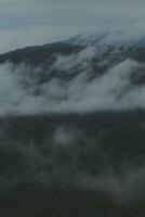 mooi panoramisch visie van mist en wolken in ver weg lagen bergen reeks met blauw lucht in ochtend- foto