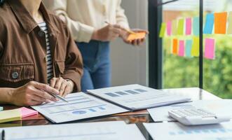 bedrijf mensen werken Aan kleverig aantekeningen creatief schrijven naar beneden ideeën Aan post het aantekeningen professioneel investeerder begin omhoog project bedrijf. foto