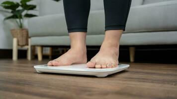 voeten staand Aan elektronisch balans voor gewicht controle. meting instrument in kilogram voor een eetpatroon controle foto