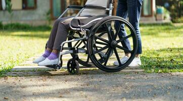 verpleging huis. jong verzorger helpen senior vrouw in rolstoel. foto