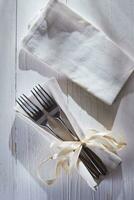 een paar- van vorken en een servet gebonden met een lint foto