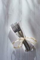 een paar- van vorken en een servet gebonden met een lint foto