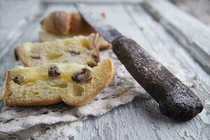 een mes en een stuk van brood Aan een tafel foto