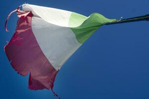 de Italiaans vlag versleten door de wind foto