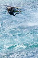 een Mens het windsurfen in de oceaan foto