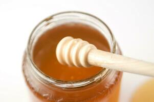 honing druipend van een houten stok foto