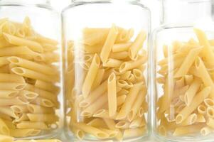 drie glas potten gevulde met pasta foto