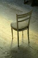 een stoel zittend Aan een beton verdieping foto