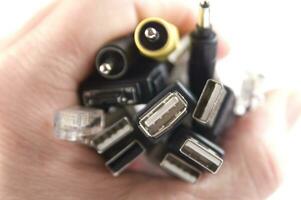 een hand- Holding meerdere verschillend types van kabels foto