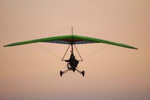 een persoon vliegend een hangen zweefvliegtuig in de lucht foto