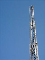 een hoog metaal toren met een blauw lucht in de achtergrond foto