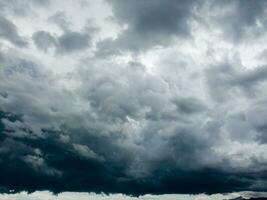 een groot donker wolk is gezien over- een lichaam van water foto