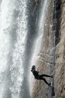 een persoon Aan een touw beklimming omhoog een waterval foto