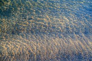 de water is Doorzichtig en blauw met zand foto