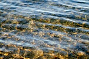 de water is Doorzichtig en blauw met zand foto