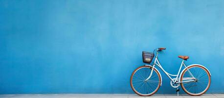 een hoge kwaliteit foto van een fiets is gepositioneerd tegen een blauw muur, met leeg ruimte beschikbaar