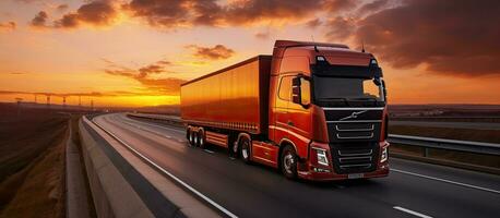 een vrachtauto met een aanhangwagen is het rijden Aan de snelweg Bij nacht met een oranje zonnig zonsondergang in de foto