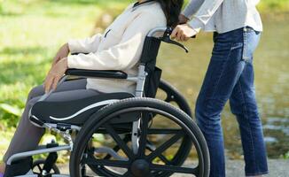 verpleging huis. jong verzorger helpen senior vrouw in rolstoel. foto