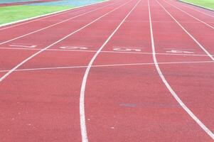 rennen bijhouden en groen gras, direkt atletiek rennen bijhouden Bij sport stadion foto