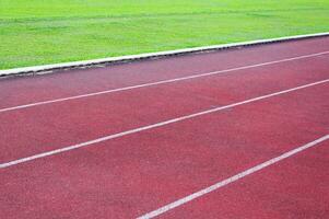 rennen bijhouden en groen gras, direkt atletiek rennen bijhouden Bij sport stadion foto