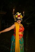 een traditioneel Javaans danser staat en dansen met een flexibel lichaam terwijl vervelend zonnebril foto