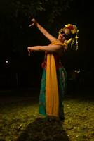 een traditioneel Indonesisch danser dansen met de lichaam draaien Aan stadium foto