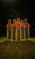 een groep van Indonesisch traditioneel dansers dans met hun vrienden in voorkant van de stadium lichten foto
