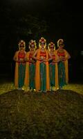 een groep van Indonesisch traditioneel dansers dans met hun vrienden in voorkant van de stadium lichten foto