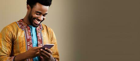 aantrekkelijk Afrikaanse Mens in Afrikaanse kleding gelukkig sms'en Aan zijn telefoon in een mode op te slaan foto