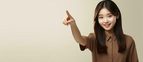 gelukkig jong Aziatisch vrouw in bruin overhemd richten naar leeg ruimte foto