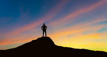 silhouet van zakenman op bergtop over zonsondergang hemelachtergrond, zaken, succes, leiderschap en prestatie concept foto