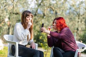 vriendinnen die smartphone gebruiken en sigaretten roken