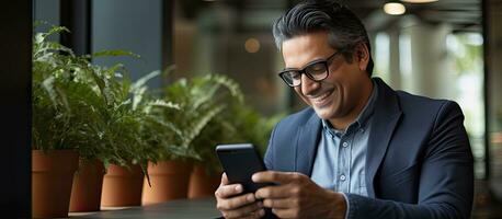 volwassen zakenman gebruik makend van mobiel app en laptop in kantoor glimlachen foto