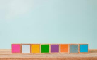 houten blokken van veel kleuren geregeld Aan een houten tafel, pastel tonen. foto