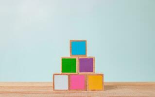 houten blokken van veel kleuren geregeld Aan een houten tafel, pastel tonen. foto