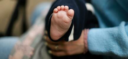 banier de baby is in de armen van de moeder. de pasgeboren slaapt Aan de straat. baby voet foto