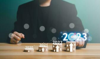 2023 bedrijf planning, strategie, creatief, idee concept. zakenman richten tabel diagram met 2023 bedrijf, groei, instelling doel, doelstelling, doelwit, doel, nieuw jaar oplossing, bedrijf marketing. foto