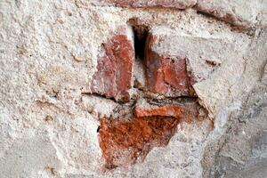 dichtbij omhoog buitenshuis wijnoogst stenen muur met beschadigd gips. grungy steen muur rechthoekig oppervlak. foto