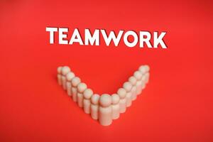 teamwerk, medewerking, bedrijf succes, leiderschap concept. samenspel tekst Aan rood achtergrond met houten figuur, samenwerking, eenheid, groep van medewerkers, het rijden, succes, vernieuwend strategie ondersteuning foto