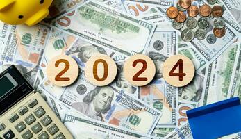 2024 tekst in houten cirkel Aan bankbiljetten achtergrond, credit kaart, spaarvarken, rekenmachine. bedrijf doelen, toekomst planning doelen, kans, uitdaging, begroting, bedrijf strategie en financieel foto