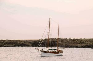 een zeilboot in de oceaan Bij zonsondergang foto