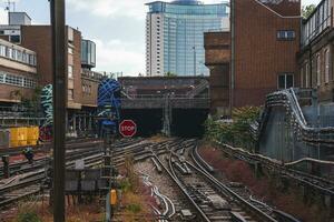 spoorweg sporen temidden van gebouwen leidend naar tunnel. foto