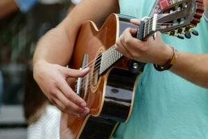 Mens spelen een akoestisch gitaar in een park foto